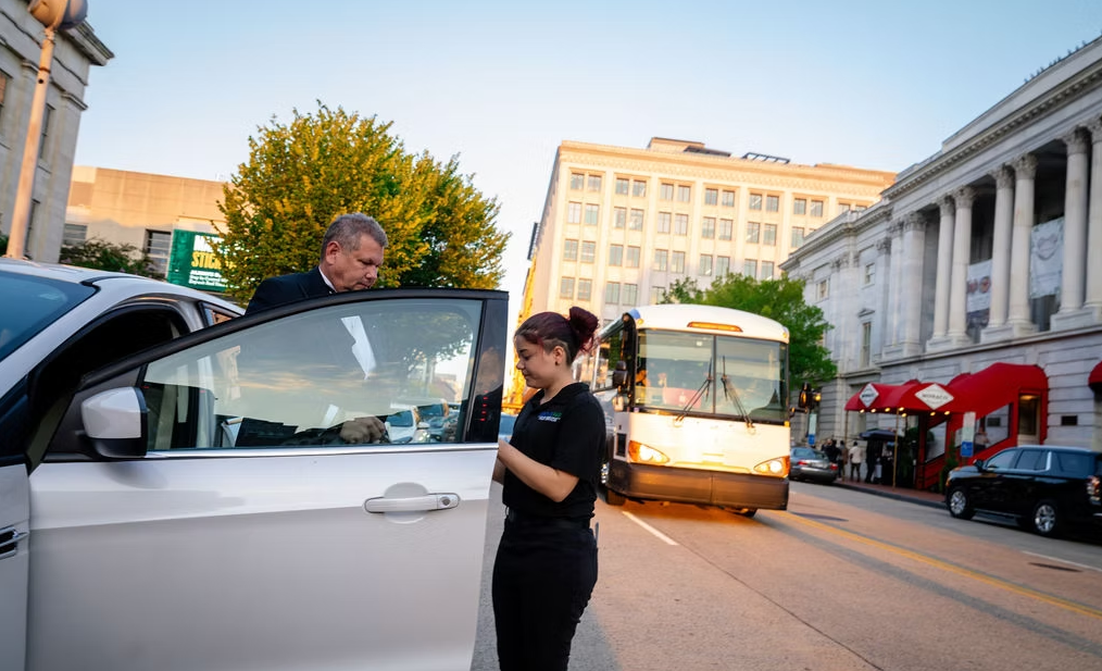 Valet opening a car door on a D.C. street
