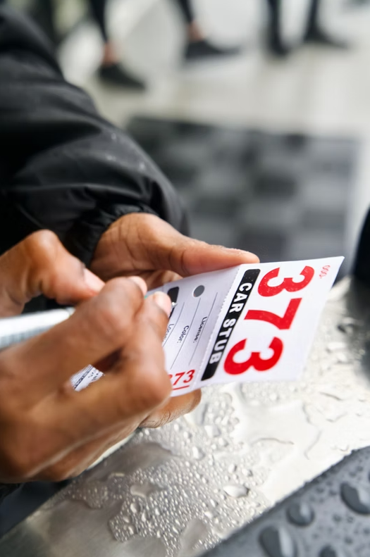 Valet writing on a numbered car-stub ticket
